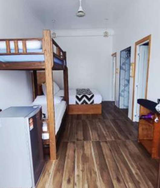 Bunk bed and wooden floor leading to the bathroom